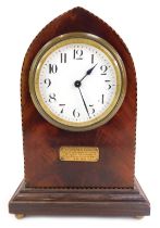 An early 20thC mahogany mantel clock, the circular white enamel dial bearing Roman numerals, key