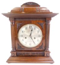 An early 20thC oak cased mantel clock, the circular silvered dial bearing Arabic numerals, eight