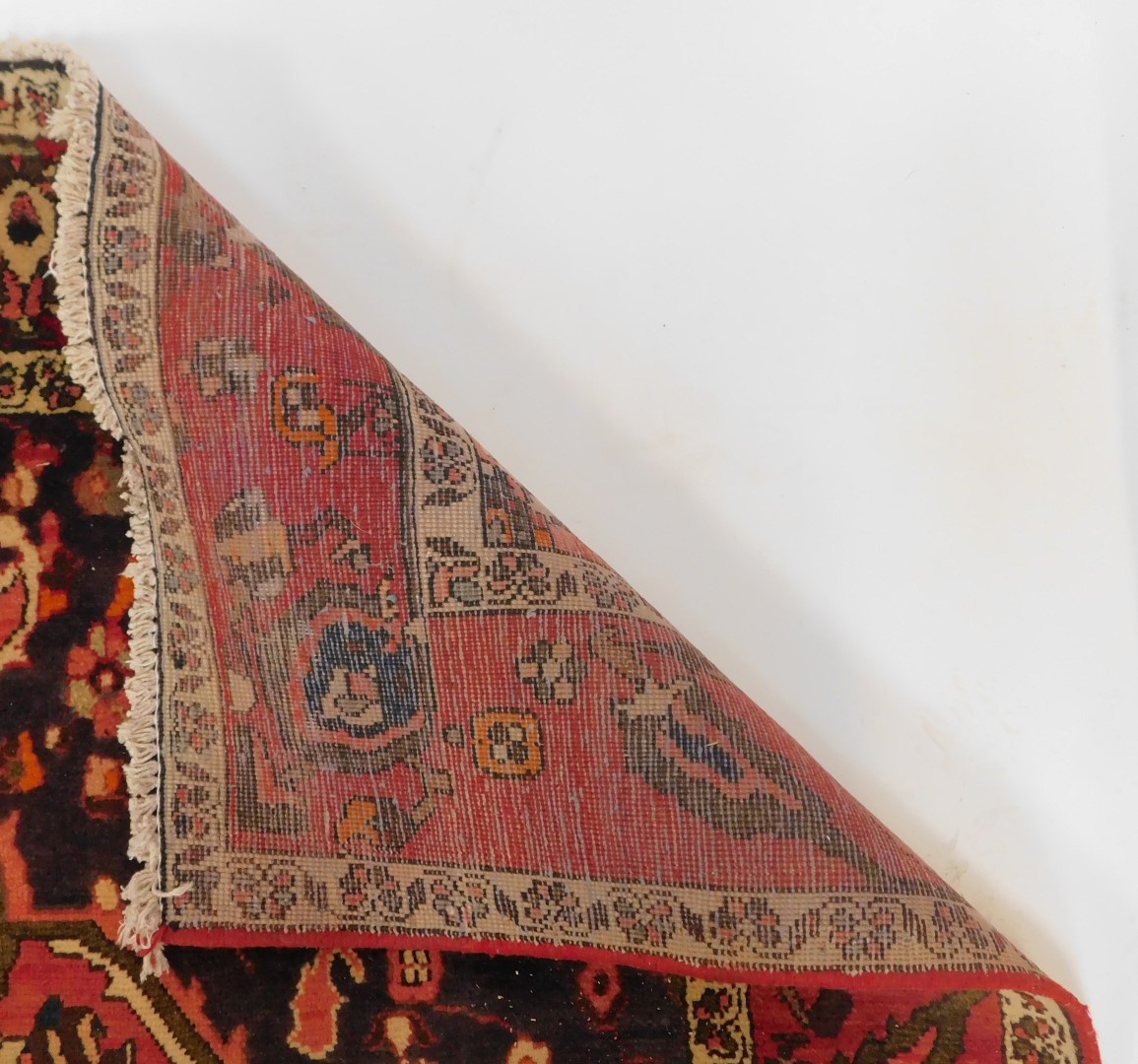 A Persian red ground rug, decorated centrally with flowers within one wide and two narrow borders, - Image 4 of 4