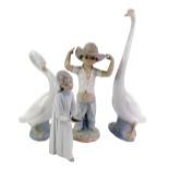 A group of Nao, comprising two geese, 34cm high and 25cm high, figure of a young boy wearing hat,