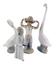 A group of Nao, comprising two geese, 34cm high and 25cm high, figure of a young boy wearing hat,