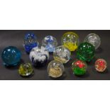 A group of paperweights, comprising a green and red butterfly domed paperweight, a turquoise bubbled