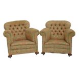 A pair of Victorian armchairs, each with a curved studded back upholstered in floral fabric, on