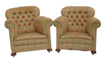 A pair of Victorian armchairs, each with a curved studded back upholstered in floral fabric, on