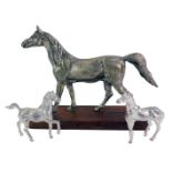 A 20thC model of a galloping horse, with silvered finish, on wooden rectangular base, with two
