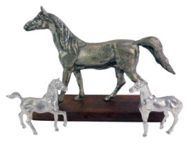 A 20thC model of a galloping horse, with silvered finish, on wooden rectangular base, with two
