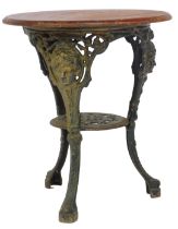 An early 20thC pub table, the stained oak top above a cast iron base decorated with masks,