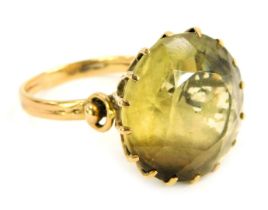 A citrine dress ring, the circular stone in a raised claw basket setting, on a yellow metal band,