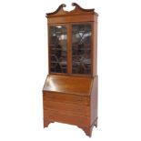 A late 19thC mahogany and inlaid bureau bookcase, the top with swan neck pediment above a