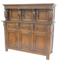 A 20thC oak court cupboard, the top with a moulded edge above a carved section above three