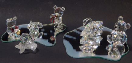 A group of Swarovski crystal animals, comprising snail, clam, swan, three Teddy bears, a hare, and