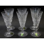 A set of six Waterford crystal Tramore pattern fluted champagne glasses, some with paper labels,