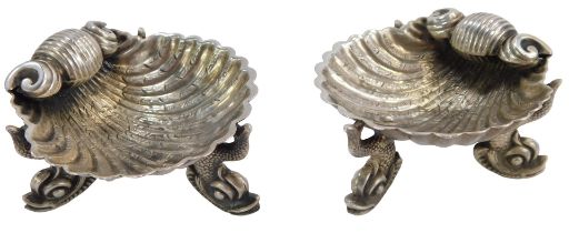 A pair of George V silver shell salts, each on tripod serpent feet, Birmingham 1924, 1.58oz.