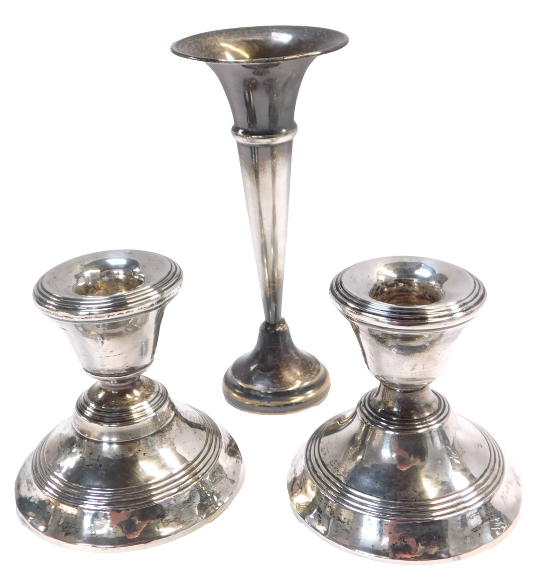 A pair of silver dwarf candlesticks, each of plain design, on a waisted foot, with rubbed hallmarks,