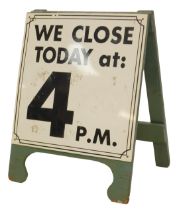 A blue painted A frame board, the white sign with black writing and border for We Close Today at