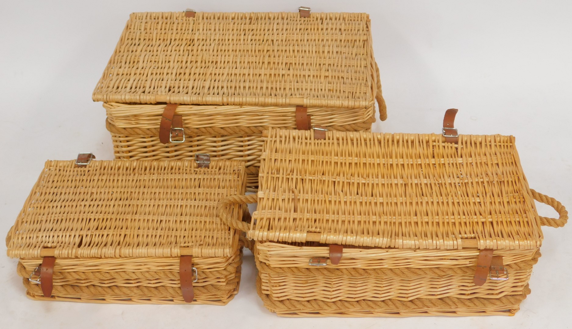 A graduated set of three wicker hampers, with brown leather straps, the largest 77cm wide. - Image 2 of 3