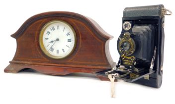 An early 20thC mahogany cased mantel clock, the circular white enamel dial bearing Arabic