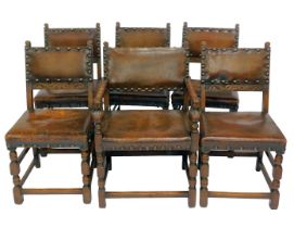 A set of six oak dining chairs, each with a leather seat and back with stud work, on turned legs