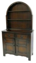 A 20thC oak dresser, the arched top with two plate shelves, the base with two drawers above two