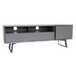 A modern TV unit, in grey, the rectangular top with a recess and drawer beside a cupboard, on