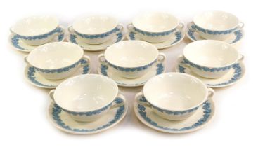 Nine Wedgwood twin handled soup bowls and saucers, each with raised blue vine and grape decoration