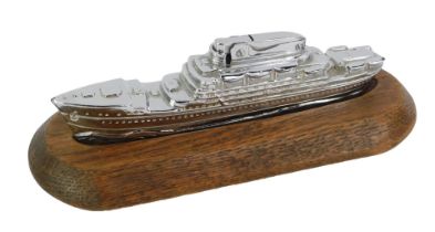 An MTC chrome novelty table lighter, modelled as a cruise liner, 16cm long, on an oak base.