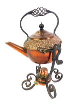 A late 19th/early 20thC Arts & Crafts copper teapot on stand, the teapot with hammered decoration,