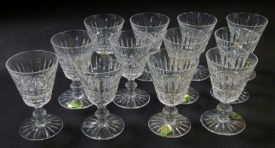 A set of twelve Waterford crystal Tramore pattern port glasses, each 10cm high, some with paper