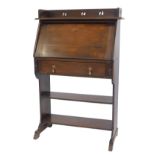 An early 20thC oak student's type bureau, the top with a moulded edge with raised carved pierced