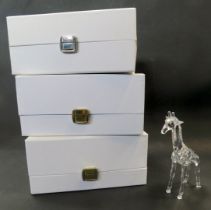 A Swarovski crystal figure modelled as a giraffe, 14cm high, boxed, together with two further boxes,