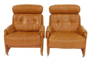 A pair of 1970s brown leather armchairs, each with a headrest, buttoned back and seat, on castors,