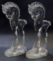 A pair of early 20thC moulded glass horse figures, modelled with elongated legs, on circular