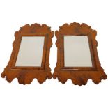 A pair of 20thC simulated burr wood fret style wall mirrors, each with a rectangular bevelled mirror
