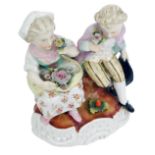 A late 19thC Sitzendorf porcelain figure group, modelled as two seated children with flowers, on