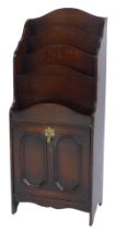 An early 20thC oak magazine rack, with a waterfall top with four recesses, the base with a