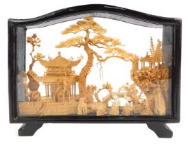 A Chinese carved cork picture, depicting storks before pagodas, with trees, in a black frame, 14.5cm