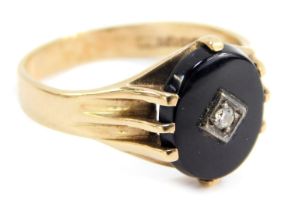 A 9ct gold dress ring, set with oval onyx and central tiny diamond, in four claw mount, with rub