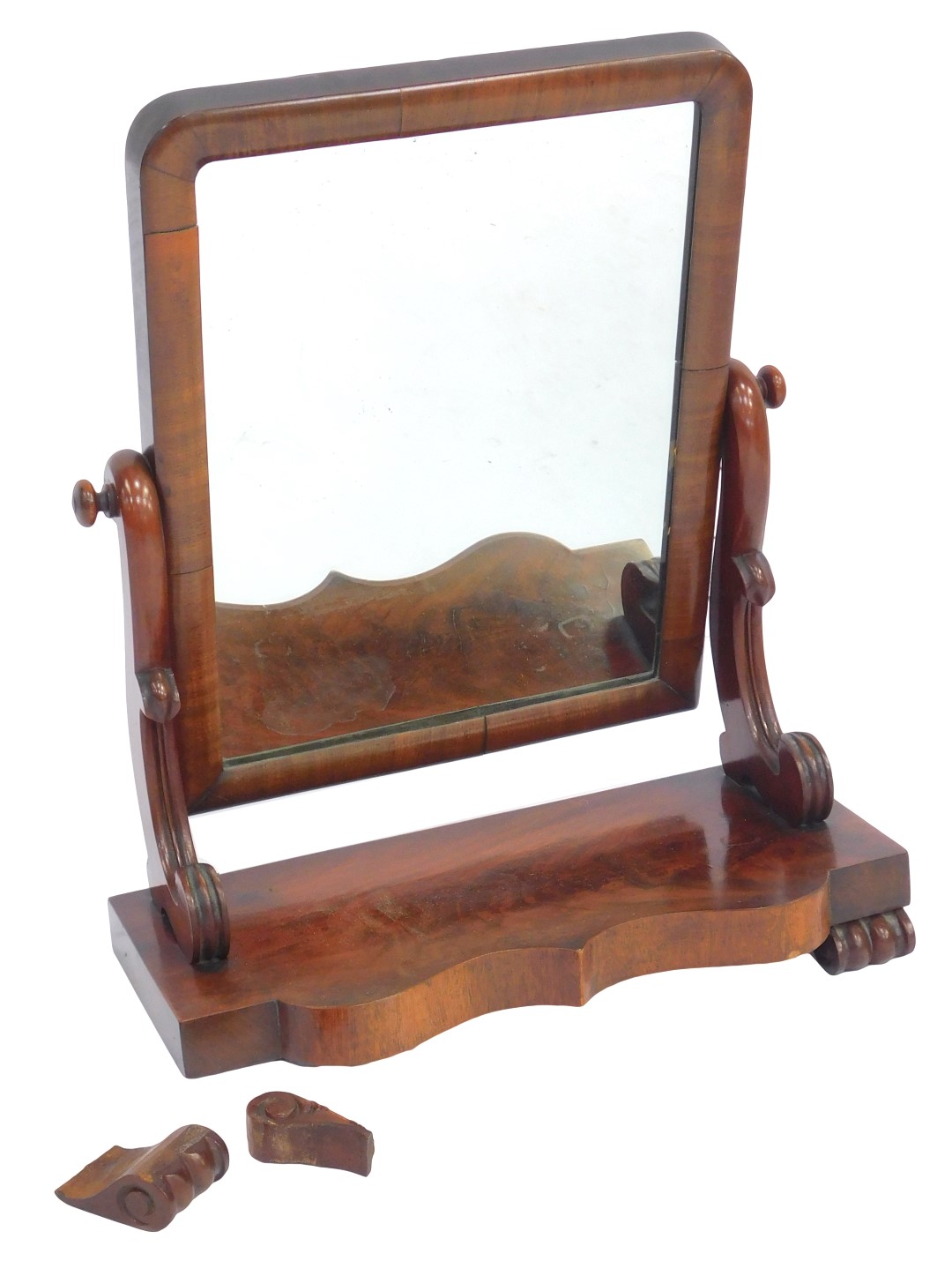 A Victorian mahogany swing frame mirror, the rectangular mirror on scrolling supports, on a shaped