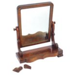 A Victorian mahogany swing frame mirror, the rectangular mirror on scrolling supports, on a shaped