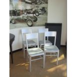 A set of four aluminum metal dining chairs.