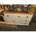 A pine and white painted sideboard, with a single drawer above two cupboards and three drawers.