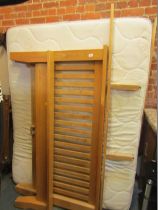 An ash finish double bed, with a wooden frame and mattress.