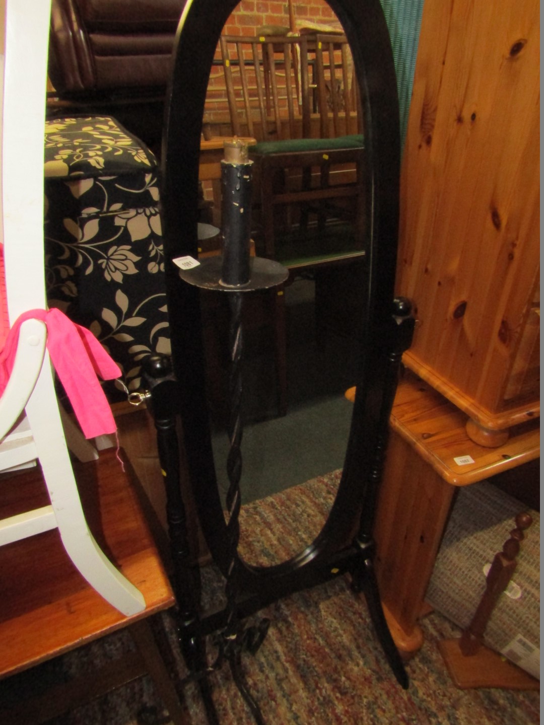 A black finish candle stand, and a black cheval mirror.