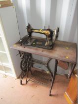 A Singer sewing machine table, on a metal framed base with Singer sewing machine.
