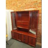 A mahogany display unit with a drinks cabinet, flanked by glazed .