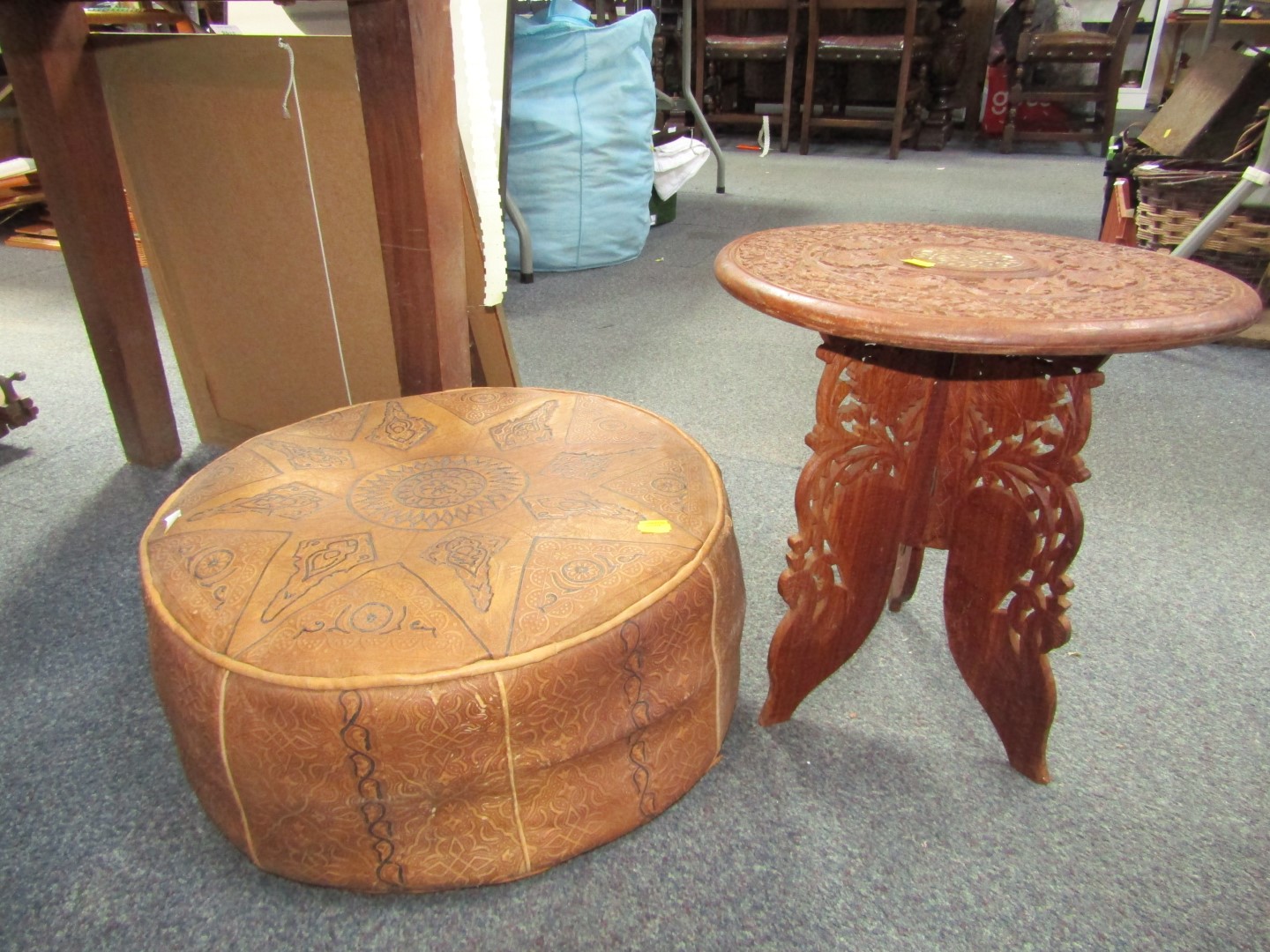 An Eastern circular side table, on a collapsible three fold base, and a footstool. (2) The