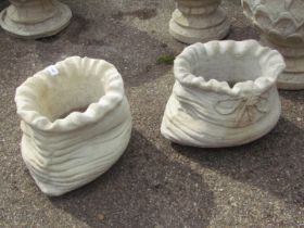 A pair of reconstituted stone sack shaped planters, 22cm high, 32cm wide.