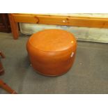 A tan leather footstool, with an embossed design. The upholstery in this lot does not comply with