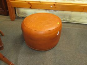 A tan leather footstool, with an embossed design. The upholstery in this lot does not comply with