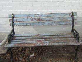 A wooden slatted garden bench painted blue, with painted metal ends.